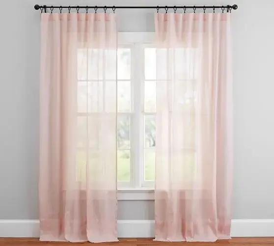 A sheer linen curtain diffusing sunlight softly
