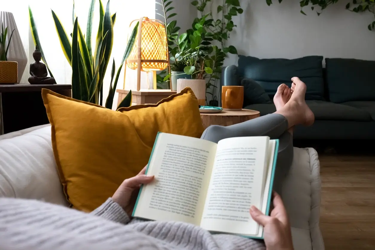 A person enjoying a book in a cozy, well-lit reading nook
