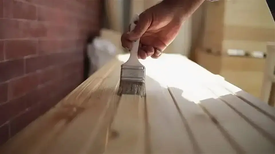 A hand touching a textured wooden surface
