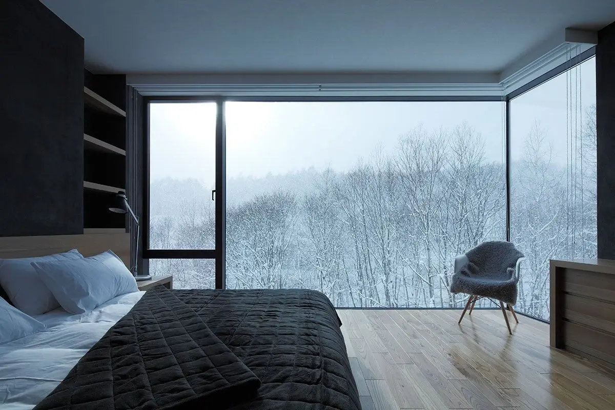 Minimalist bedroom with a large window overlooking the city